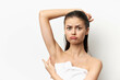 © SHOTPRIME STUDIO - Woman with an annoyed expression showing concerns about her underarm hair, standing against a clean white background, emphasizing personal grooming and self image issues