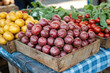 © kristina - Wooden crate bursting with colorful fresh vegetables under sunny skies at a local farmers' market.