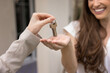© fizkes - Realtor giving key to happy young renter woman. Cheerful new tenant, property buyer, homeowner woman ready to move into new apartment. Cropped shot of hands of agent and customer