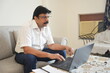 © GAJENDRRA BHATI  - mature indian man working on laptop in a calm home setting. businessman and work from home concept.