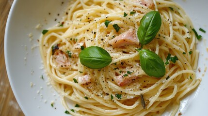 Poster - Overhead view of creamy pasta with smoked fish topped with fresh basil and cracked pepper on a rustic plate