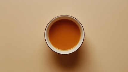 Aufkleber - Overhead view of a bowl filled with creamy orange soup on a minimalist background showcasing culinary elegance and comfort food appeal