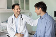 © fizkes - Cheerful supportive empathetic doctor man touching shoulder of patient on appointment in hospital office, congratulating on successful treatment result, rehabilitation, good checkup