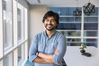 © fizkes - Happy confident Indian company director man standing in office space with arms folded confidence gesture, looking at camera, smiling. Positive businessman, CEO, business owner head shot portrait