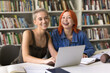 © fizkes - Best friends. Portrait two happy pretty females young students undergraduates with diverse stylish look trendy colored hair spend time for self-study at library sit at desk by notebook look at the