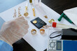 © lesslemon - A pawn shop employee tests old gold jewelry using reagents and a touchstone, Buying old gold, closeup