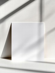 Leinwandbilder - White sheet of paper casting shadows in a minimalistic indoor setting during daylight hours. Generative AI