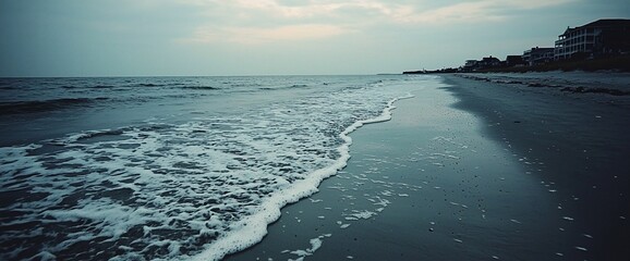 Poster - Serene coastal scene at dusk, waves gently lapping the shore.