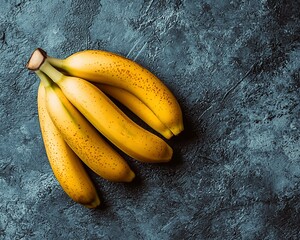 Sticker - Overhead view of a bunch of ripe yellow bananas on a dark textured surface.