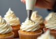 © puruan - Decorating vanilla cupcakes with creamy frosting at a culinary workshop