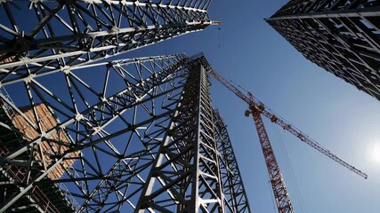 Aufkleber - Construction cranes tower over a bustling city skyline under a clear blue sky