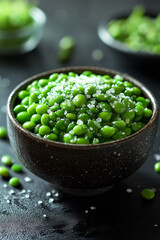 Poster - Bowl of bright green edamame beans sprinkled with sea salt on a sleek black surface,