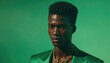 © Miklos - Stylish man poses in green light wearing a bold suit and accessories at a modern photography session