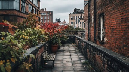 Poster - Rooftop garden path between brick buildings, autumn foliage, stone paving, bench.