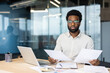 © Liubomir - Portrait of serious focused financier accountant doing paperwork, man holding financial reports in hands looking at camera, businessman doing paperwork, filling and checking tax forms, contracts.
