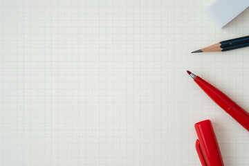 Wall Mural - top view, close-up of red felt-tip pen, pencil and eraser on graph paper, copy space for text, flat 
