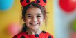 © Iryna - A little girl wearing a red and black dress with a red headband is smiling. She looks happy and content