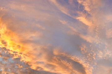 Wall Mural - A beautiful sky tinted by the sun leaving vibrant shades of gold, pink, blue and multicolored. Clouds in the twilight evening and morning sky. Cloudy sky background in the evening, and during the day.