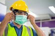 © winnievinzence - Male engineer worker wearing protective face mask, safety helmet and glasses at factory