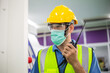 © winnievinzence - Male worker in protective mask talking on walkie-talkie with colleague to control work in front of technology machine at industrial plant factory. copy space