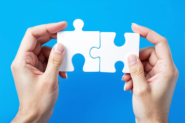 Aufkleber - Hands holding two white puzzle pieces fitting together on blue background.