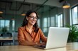 © Viktor - Happy Hispanic businesswoman working in modern office using laptop for virtual meeting. Smiling, giving presentation to colleagues online. Businesswoman looks happy, engaged in online conference.