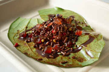 A closeup view of a paan, featuring chocolate ingredients.