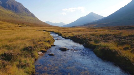 Poster - Serene valley stream winding through lush grasslands with majestic mountains under a clear blue sky