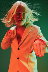 Wall Mural - stylish man with long hair in a trendy suit, posing dramatically, colorful background with green and red lighting, capturing a lively and artistic vibe characters long