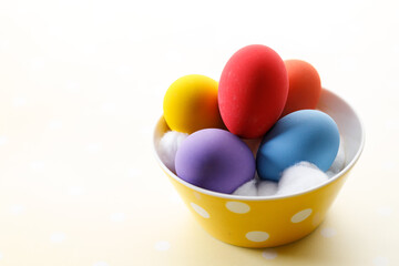 Wall Mural - Happy Easter eggs in a bowl on dot yellow color background.