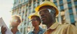 © Philipp - Construction crew examining blueprints at a site with sunlight reflecting off their helmets