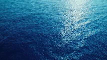 Poster - Aerial shot of tranquil blue ocean surface with reflective sunlight ideal for blank space and text overlay applications
