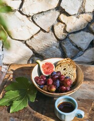 Wall Mural - Enjoying fresh figs, grapes, and bread with coffee for a mediterranean breakfast