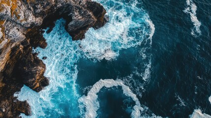 Leinwandbilder - Aerial view of ocean waves crashing against rocky cliffs with copyspace for text ideal for nature and travel themed projects