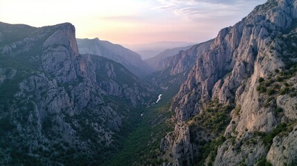 Poster - Breathtaking canyon landscape with majestic mountains and lush greenery under a serene sky at sunset
