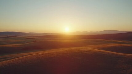 Poster - Aerial view of tranquil sunset over rolling hills with wind turbines silhouetted against the sky providing space for text insertion.