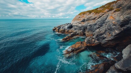 Poster - Stunning coastal landscape featuring rugged rocks and serene ocean waves under a beautiful sky