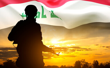 Wall Mural - Silhouette of a soldier with Iraq flag against the sunset. National Holidays concept. Military background