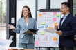 © David - Asian female ceo and multicultural business people discussing company presentation at boardroom table. Diverse corporate team working together in modern meeting room office.