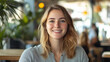 © HansAdam - Smiling woman enjoying a sunny day at a vibrant cafe with greenery and customers around