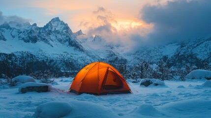 Wall Mural - Orange tent in snowy mountains at sunset.