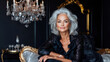 © Katerina Bond - An elegant portrait of a confident mature woman with silver hair, dressed in a sophisticated black outfit and statement jewelry. She poses in a luxurious dark interior.