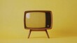 © Thirakun - A classic retro TV with a curved screen and wooden frame placed on a bright yellow background