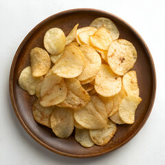 Crispy potato chips piled high on a rustic plate.