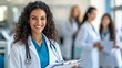 © chusnul - A smiling healthcare professional in a lab coat, surrounded by colleagues in a medical setting.