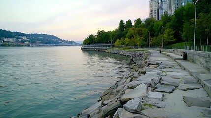 Wall Mural - background light hues relaxation concept, serene waterfront view with rocky shoreline and lush green