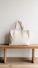 Poster - Minimalist tote bag mockup placed on a wooden bench against a clean white wall, creating a stylish and versatile backdrop for showcasing designs