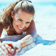 © Alliance - Happy young woman in swimsuit relaxing on beach