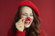 © Alliance - happy elegant woman in red sweater and beret with candy