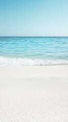 Poster - Soft white sand beach is meeting calm turquoise water with small waves under clear blue sky creating a perfect background for summer holiday travel